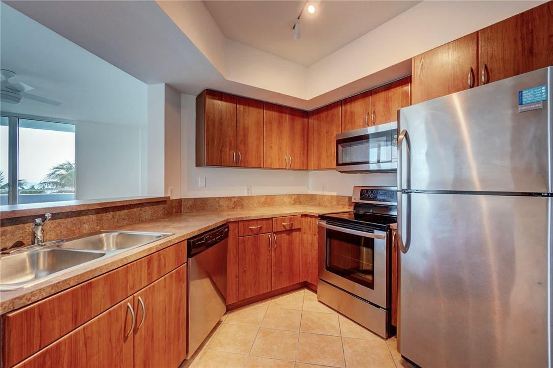 9201 Collins Avenue, Unit 326 Surfside, FL 33154 - Photo 7 of 41 a kitchen with stainless steel appliances granite countertop a sink stove and refrigerator