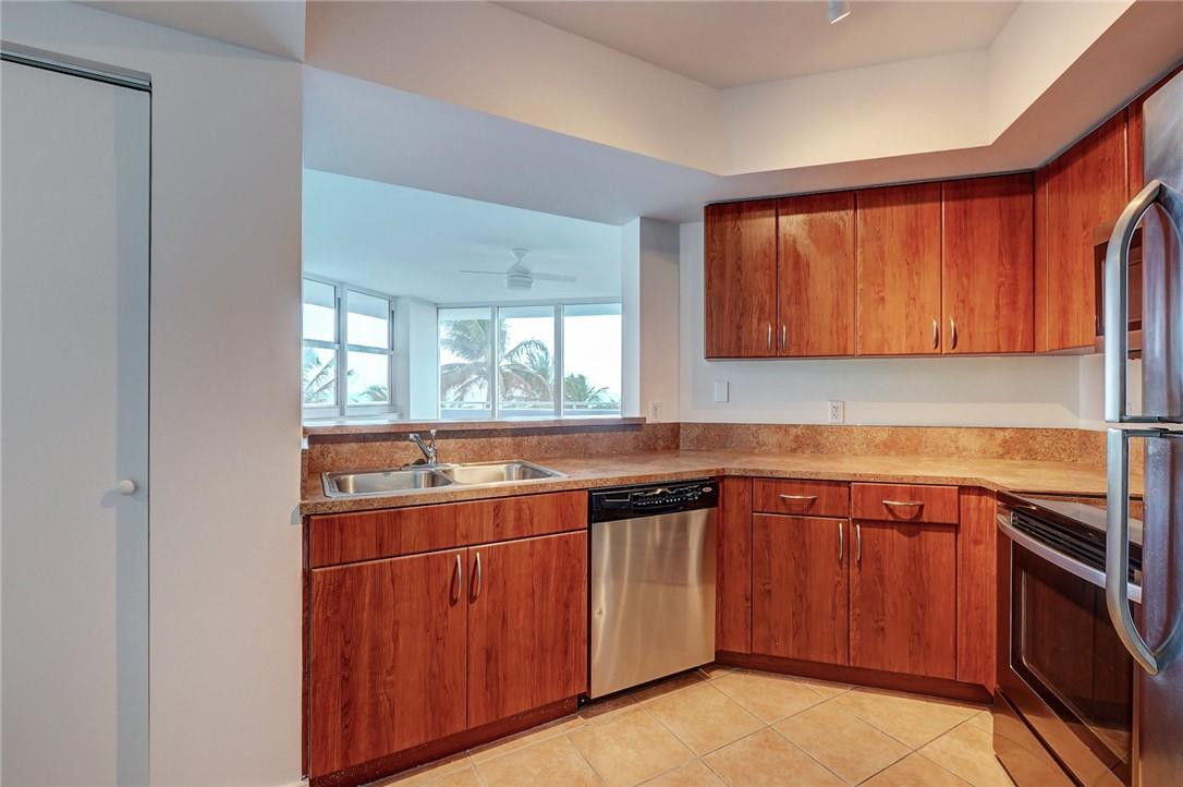 9201 Collins Avenue, Unit 326 Surfside, FL 33154 - Photo 8 of 41 a kitchen with a sink and cabinets