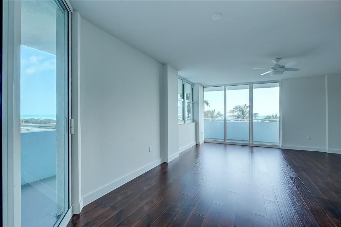 9201 Collins Avenue, Unit 326 Surfside, FL 33154 - Photo 9 of 41 an empty room with wooden floor and windows
