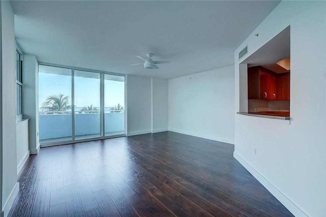9201 Collins Avenue, Unit 326 Surfside, FL 33154 - Photo 10 of 41 an empty room with wooden floor and windows