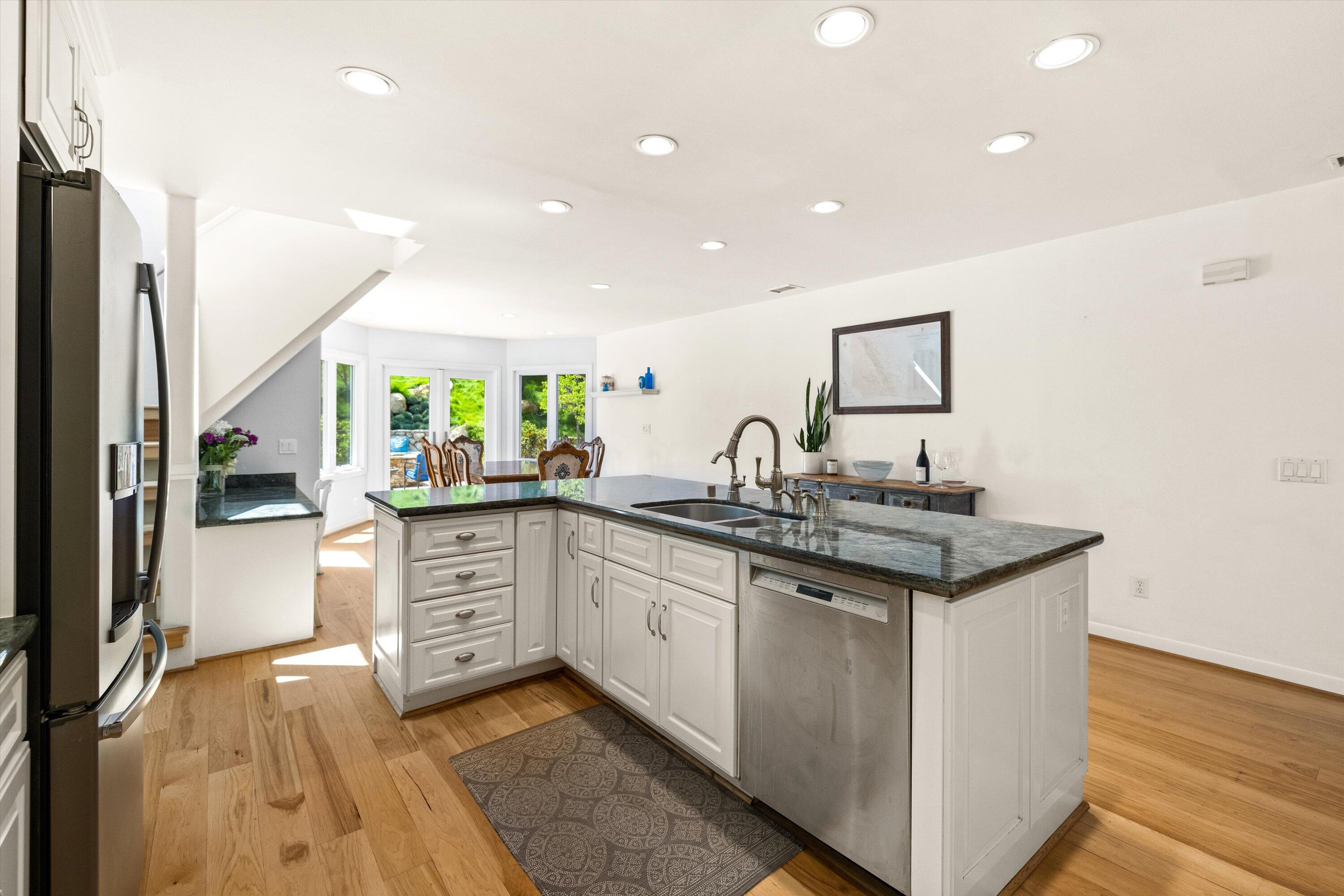 927 Randolph Road Santa Barbara, CA 93111 - Photo 7 of 25 a kitchen with stainless steel appliances granite countertop a sink and dishwasher a stove top oven with wooden floor