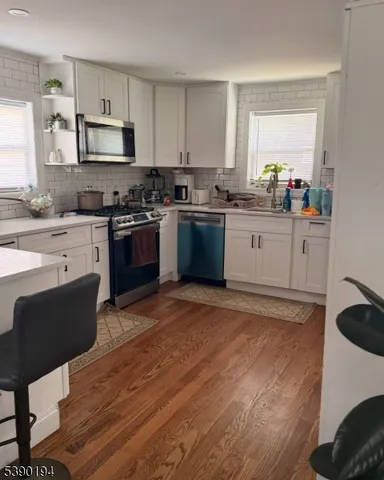 a kitchen with granite countertop a stove top oven a sink dishwasher and a refrigerator