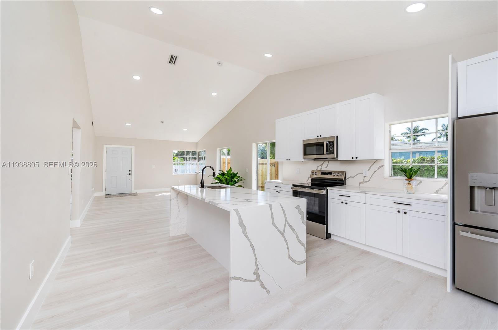 a large white kitchen with cabinets and stainless steel appliances