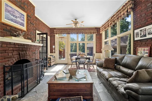 a living room with furniture a fireplace and a floor to ceiling window