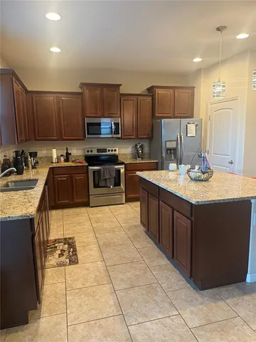 a kitchen with a sink a counter top space cabinets and stainless steel appliances