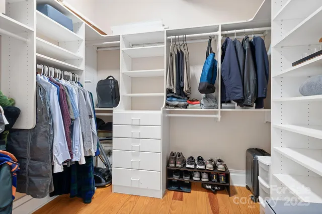 a view of walk in closet with clothes and shoes
