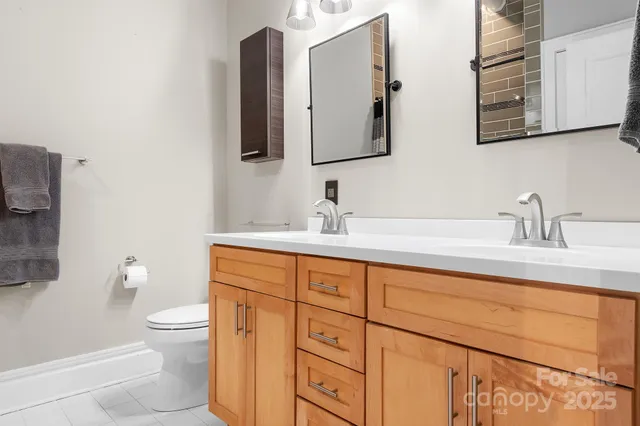 a bathroom with 2 sink toilet and a mirror
