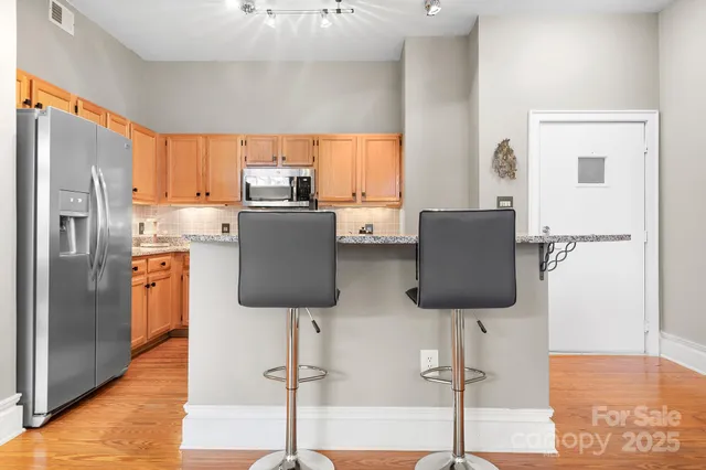 a kitchen with stainless steel appliances granite countertop a refrigerator and a stove top oven