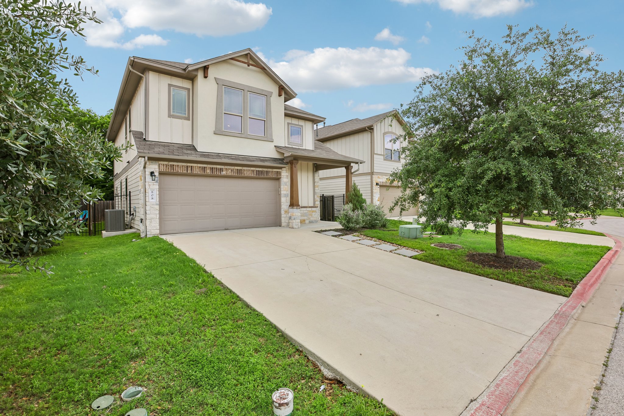808 Totis Road Austin, TX 78748 - Photo 3 of 40 Two-story residence featuring a two-car garage, concrete driveway, stone accents, and a covered entry