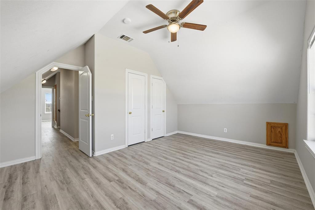 213 Private Road 4573, Unit 228 Boyd, TX 76023 - Photo 4 of 23 an empty room with wooden floor a ceiling fan and windows