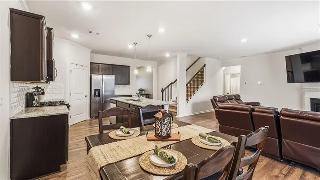 a living room with furniture kitchen view and a flat screen tv