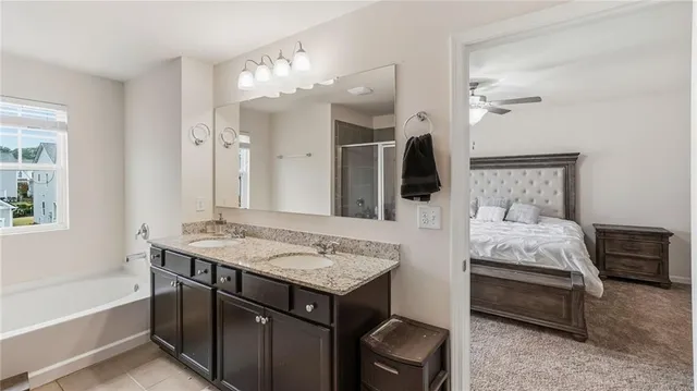 a en suite bathroom with a granite countertop sink and a mirror