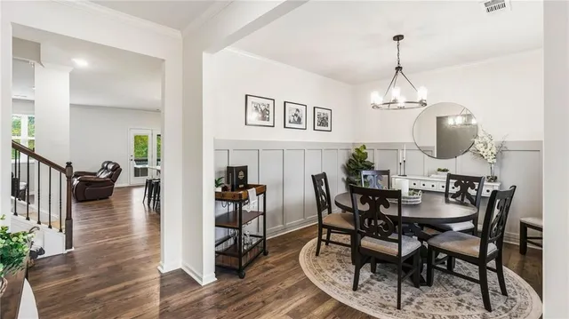 a view of a dining room and livingroom with furniture wooden floor a chandelier