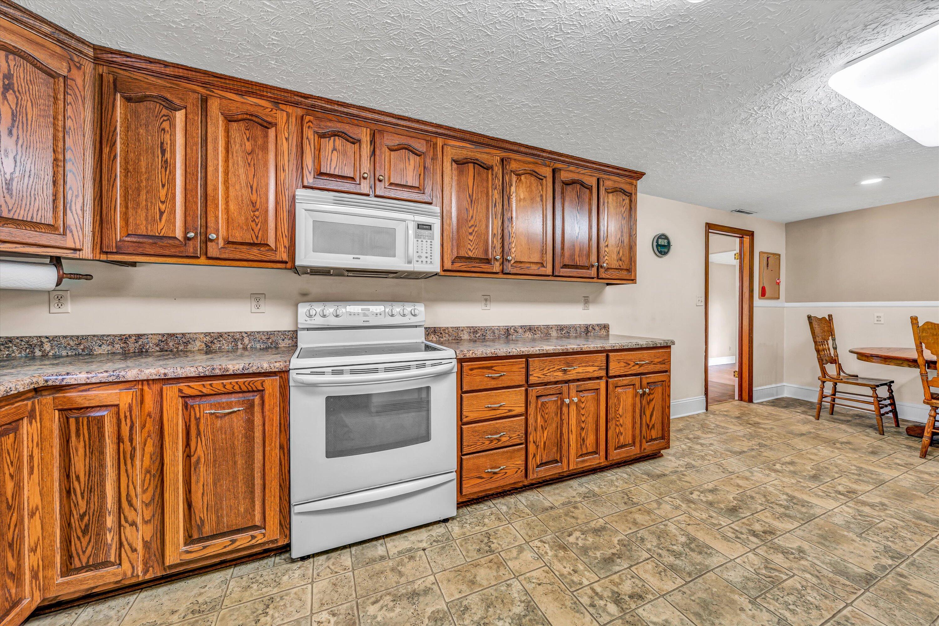 90 Campbellwood Road Boones Mill, VA 24065 - Photo 7 of 38 a kitchen with stainless steel appliances granite countertop wooden cabinets a sink and dishwasher a stove with wooden cabinets