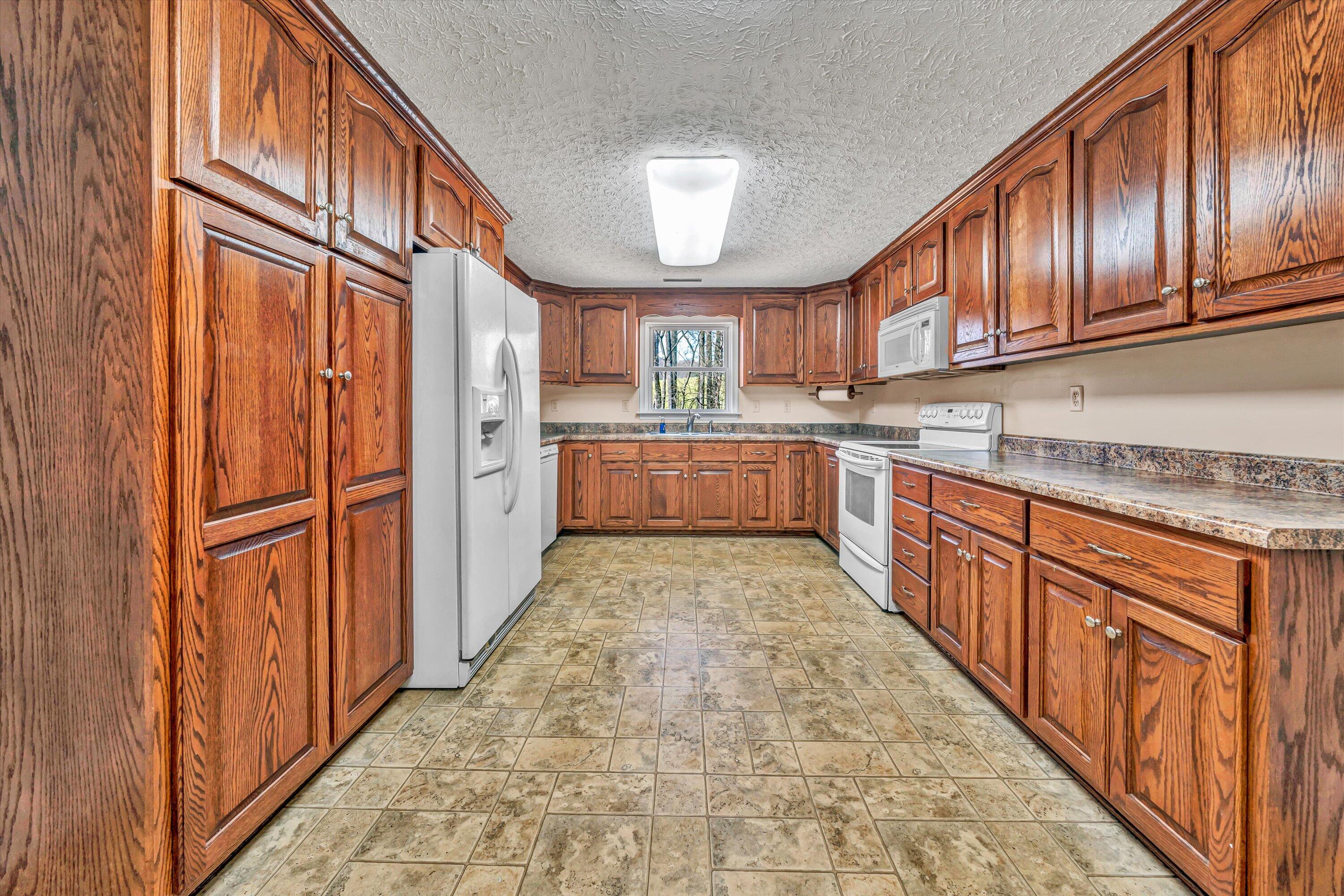 90 Campbellwood Road Boones Mill, VA 24065 - Photo 8 of 38 a large kitchen with stainless steel appliances granite countertop lots of counter top space and wooden floor