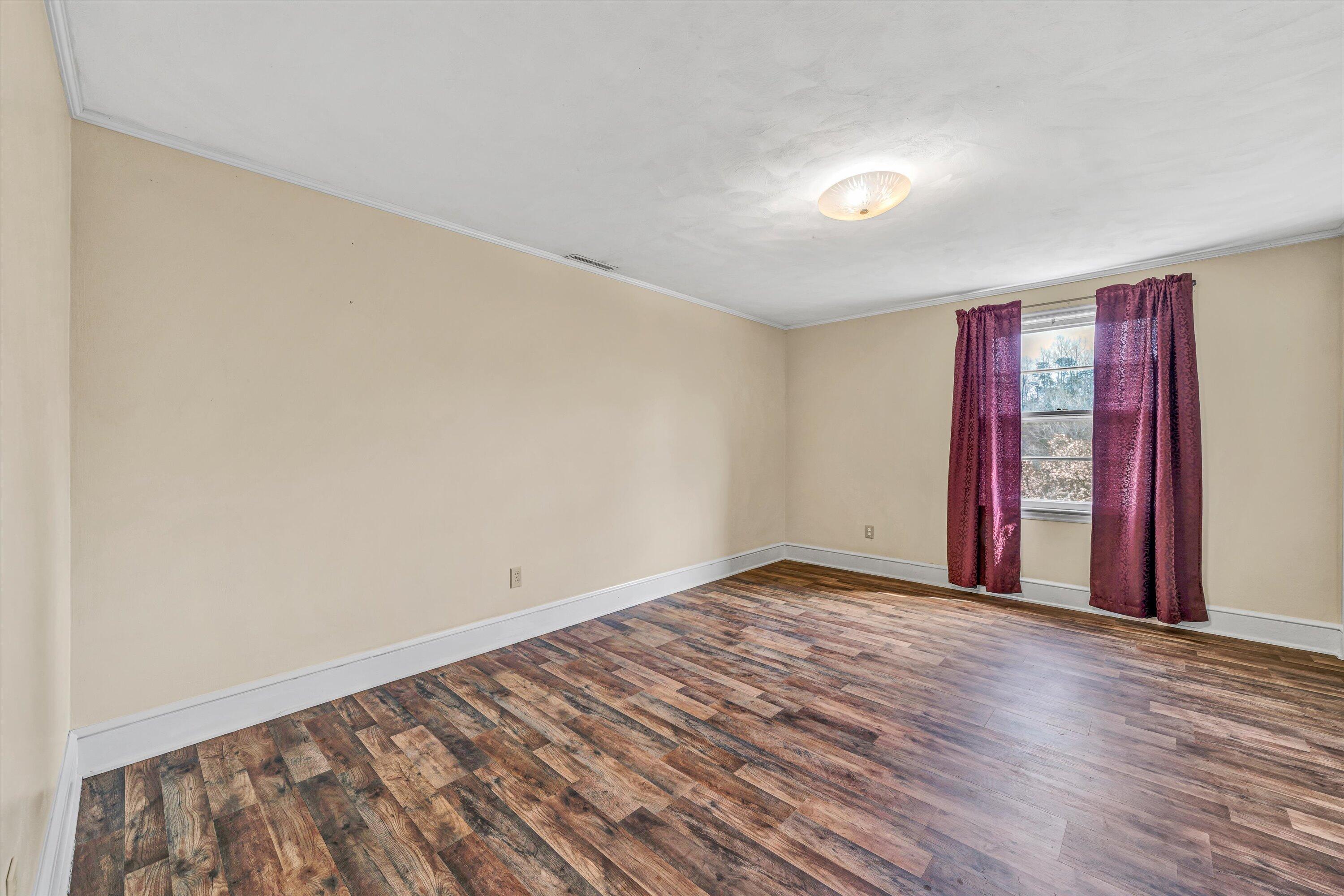 90 Campbellwood Road Boones Mill, VA 24065 - Photo 21 of 38 a view of an empty room with wooden floor and window