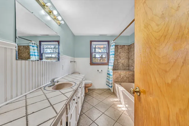 a bathroom with a toilet sink and mirror