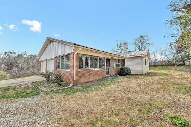 a view of a house with a yard and large tree