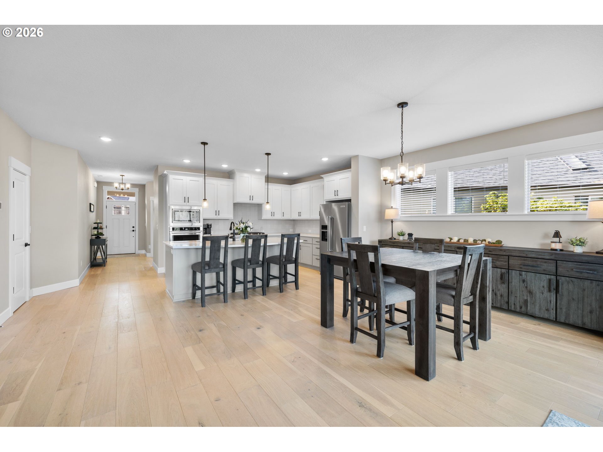 17311 Northeast 28th Court Ridgefield, WA 98642 - Photo 11 of 38 a open kitchen with stainless steel appliances kitchen island granite countertop a table chairs and a refrigerator