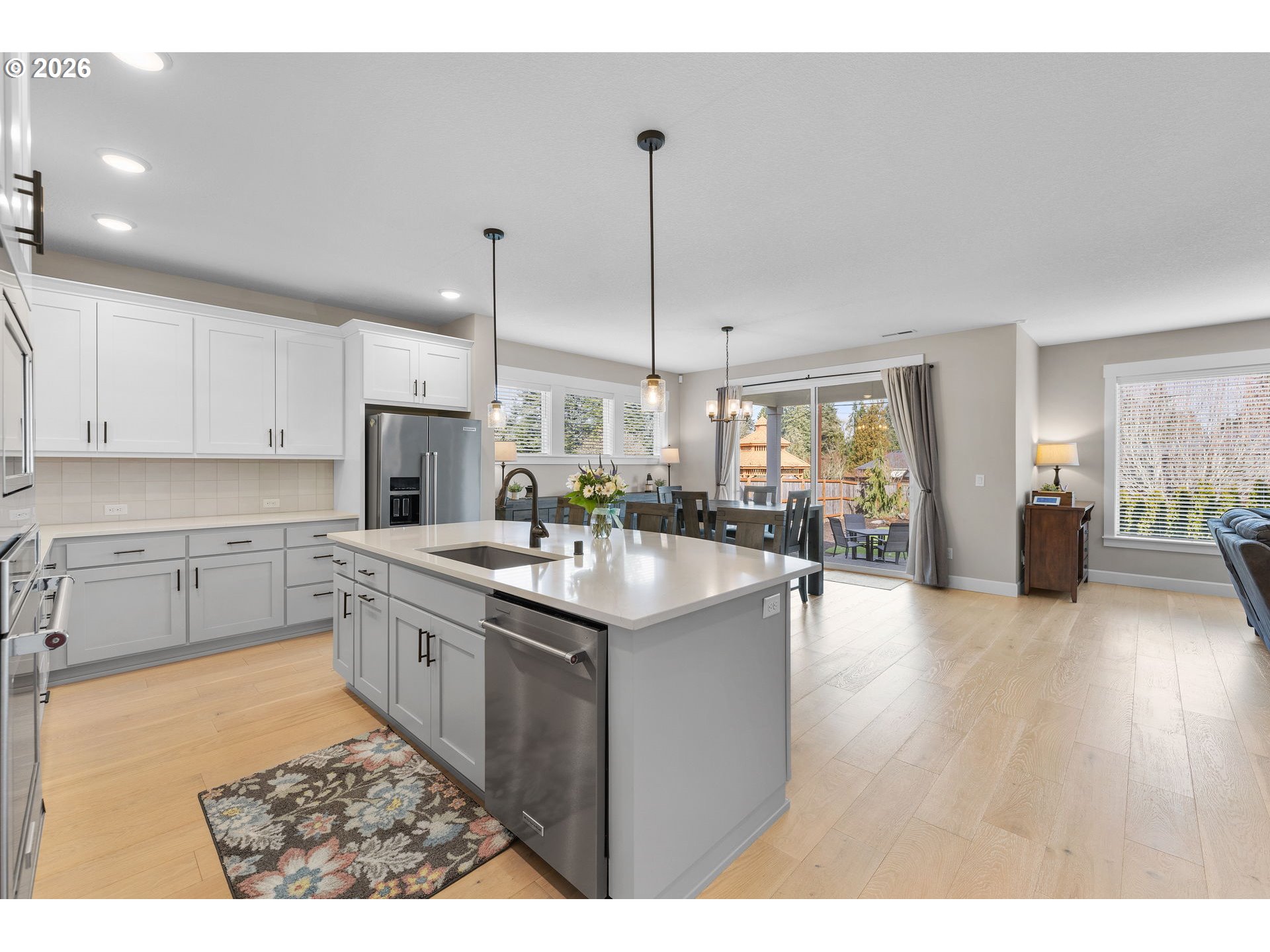 17311 Northeast 28th Court Ridgefield, WA 98642 - Photo 8 of 38 a kitchen with stainless steel appliances granite countertop a sink stove and white cabinets with wooden floor