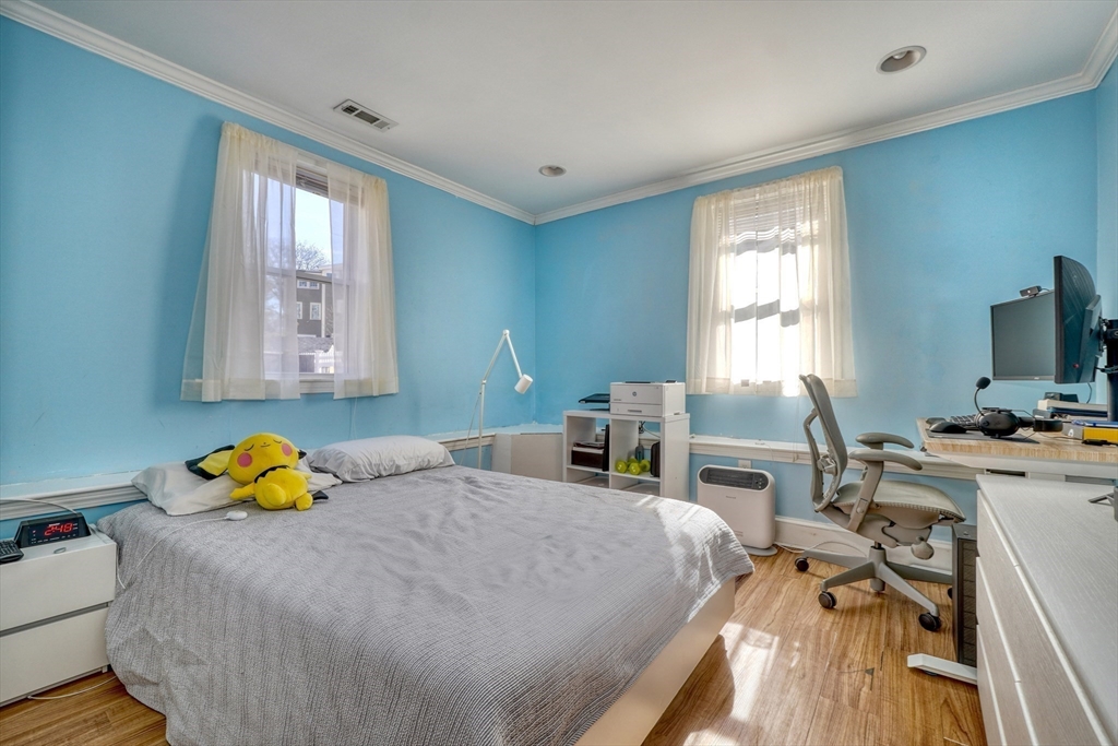 173 Overlook Road Arlington, MA 02474 - Photo 29 of 42 a bedroom with a bed a table and a flat screen tv