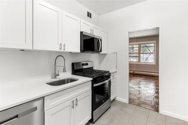 a kitchen with stainless steel appliances granite countertop a stove a sink and a microwave