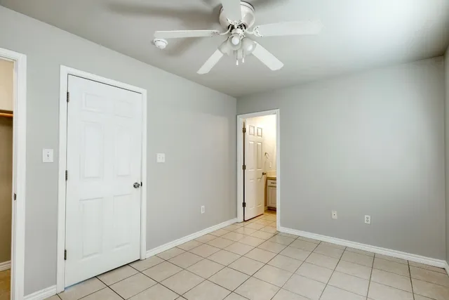 an empty room with closet and fan