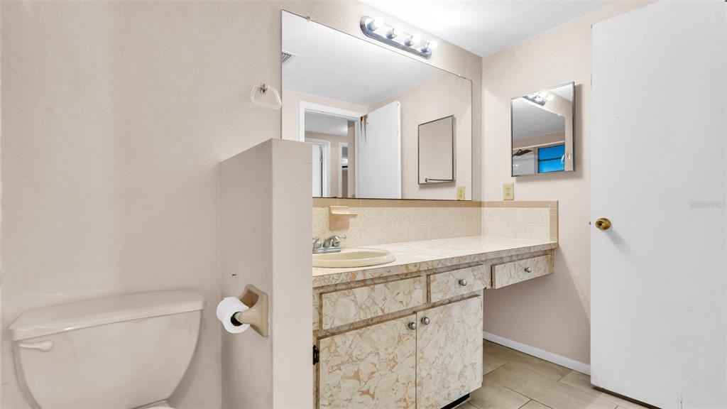 11241 Snyder Avenue Port Richey, FL 34668 - Photo 13 of 24 a bathroom with a sink a toilet and mirror