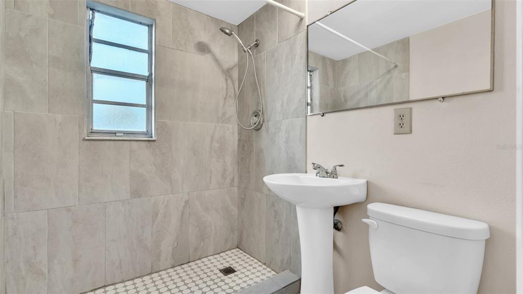 11241 Snyder Avenue Port Richey, FL 34668 - Photo 21 of 24 a bathroom with a sink a toilet and shower