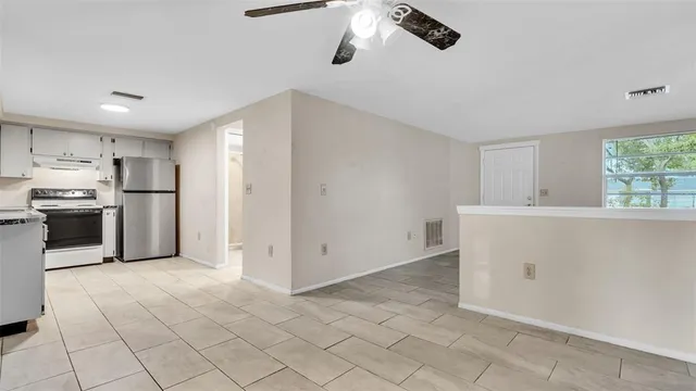 a kitchen with granite countertop white cabinets and white stainless steel appliances