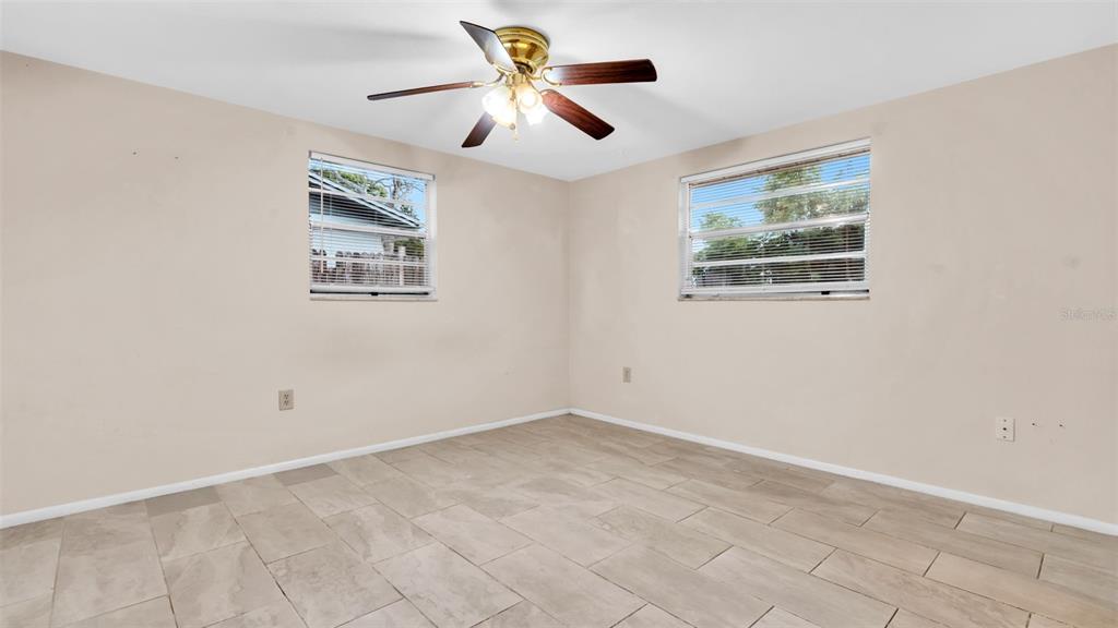 11241 Snyder Avenue Port Richey, FL 34668 - Photo 10 of 24 an empty room with a window and a fan