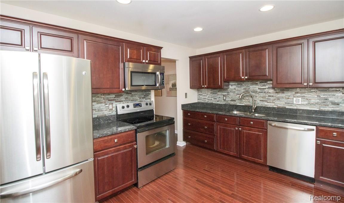 1504 Hidden Valley Lane, Unit 217 Rochester, MI 48306 - Photo 3 of 23 Step into the Lovely Kitchen with stunning tile backsplash and Stainless appliances