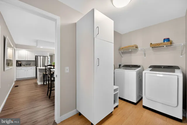 a view of a kitchen with refrigerator and wooden floor