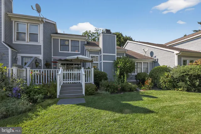 a view of a house with brick walls and a yard with plants