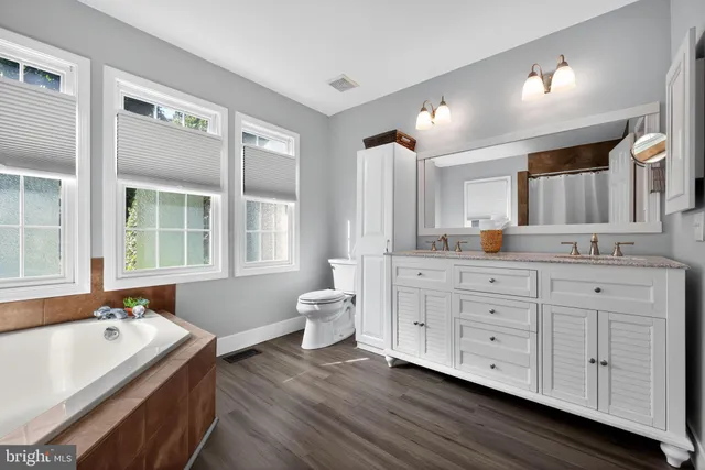 a bathroom with a granite countertop sink and a large mirror