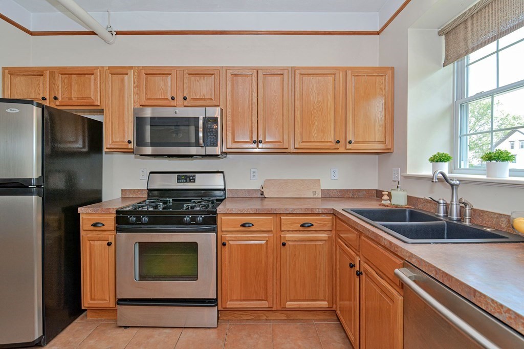 200 Cato Street, Unit 7 Woonsocket, RI 02895 - Photo 3 of 39 a kitchen with granite countertop a stove sink and microwave
