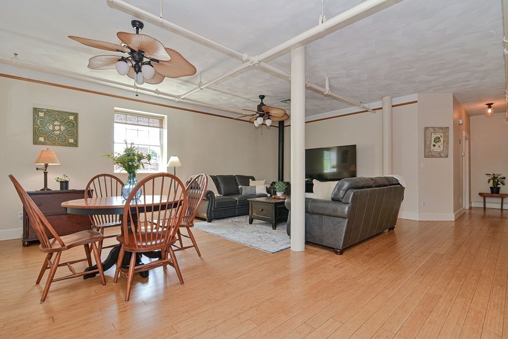 200 Cato Street, Unit 7 Woonsocket, RI 02895 - Photo 10 of 39 a living room with furniture a wooden floor and a chandelier