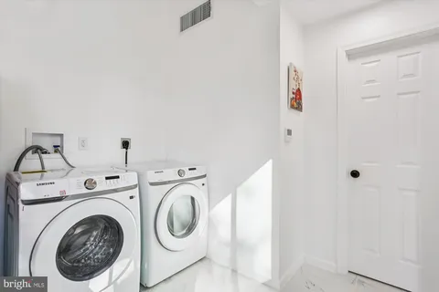 a view of an empty room with wooden floor and closet
