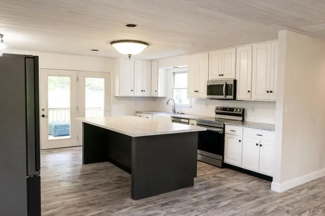 a kitchen with stainless steel appliances a sink dishwasher a stove refrigerator and cabinets