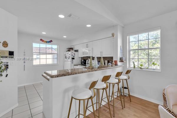 14817 Balgowan Road, Unit 2015 Miami Lakes, FL 33016 - Photo 15 of 39 a kitchen with granite countertop white cabinets and chairs