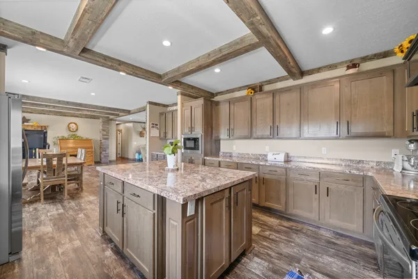 a kitchen with a sink a stove cabinets and wooden floor