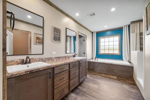 a bathroom with double vanity sinks double vanity tub shower and a mirror