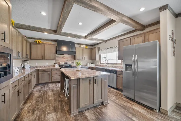 a kitchen with stainless steel appliances granite countertop a sink a stove and a refrigerator