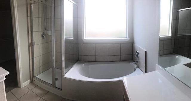 21338 Bella Flora Court Spring, TX 77379 - Photo 9 of 10 a bathroom with a bathtub and a shower
