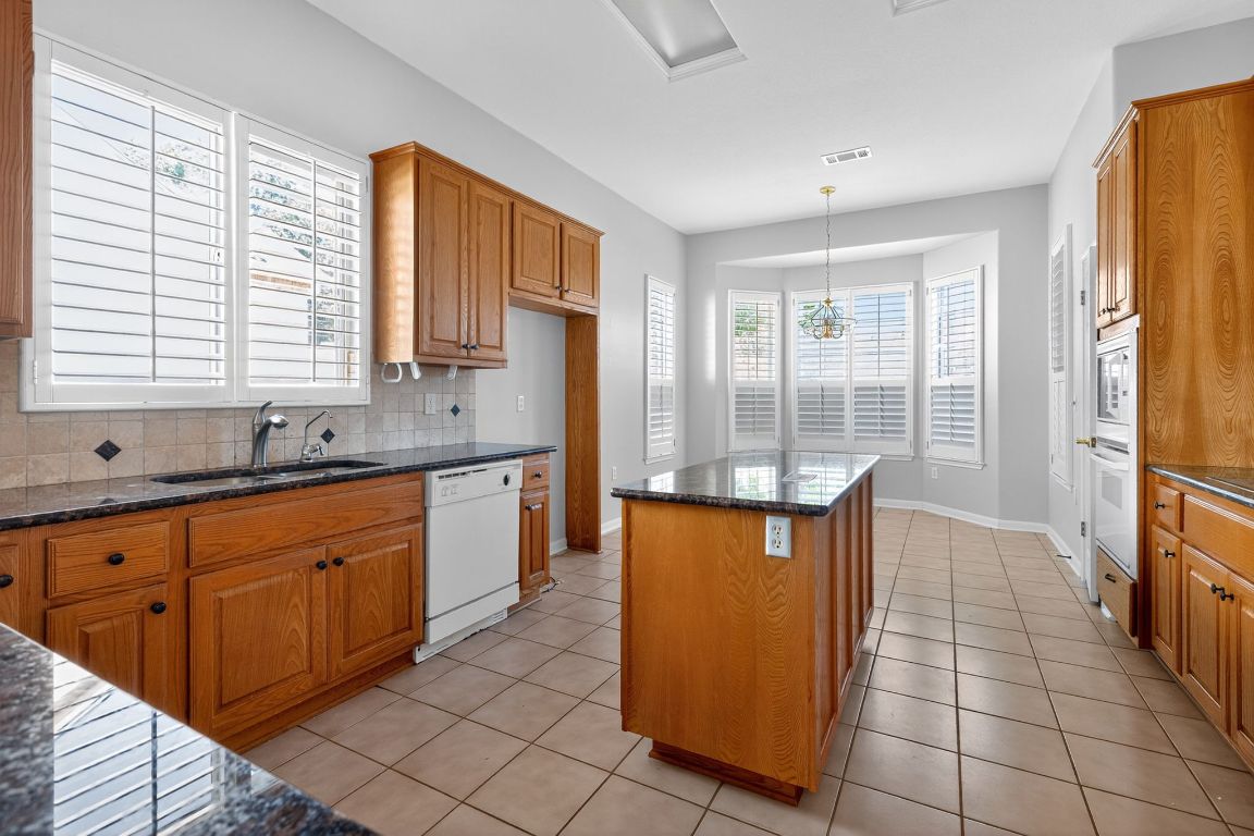 130 Crepe Myrtle Lane Georgetown, TX 78633 - Photo 12 of 33 a kitchen with stainless steel appliances granite countertop a stove a sink and a refrigerator