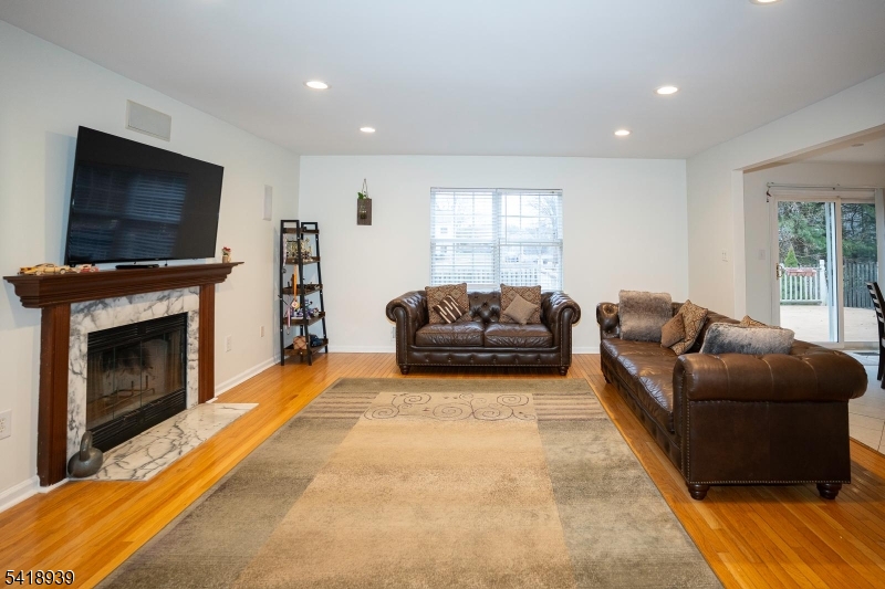 54 Campbell Road Hillsborough, NJ 08844 - Photo 8 of 31 a living room with furniture a flat screen tv and a fireplace