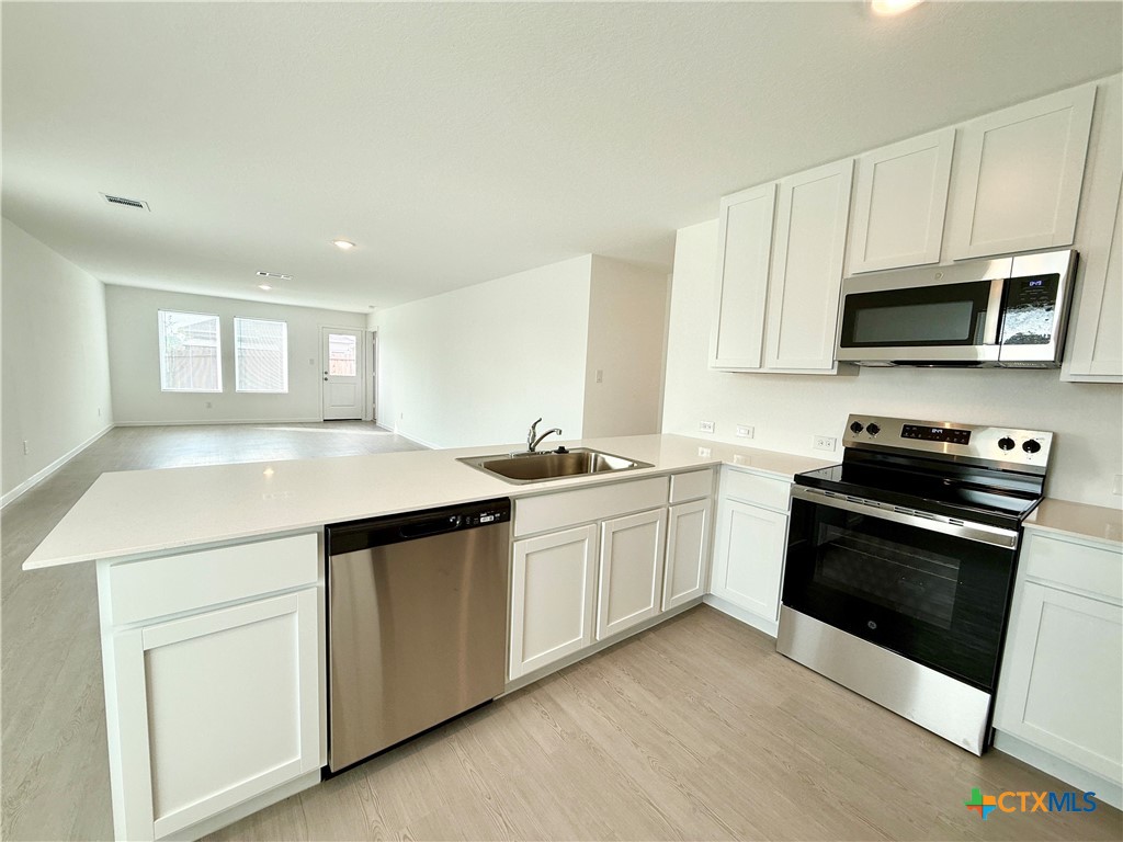 311 Moscato Road New Braunfels, TX 78130 - Photo 6 of 38 a kitchen with granite countertop a sink and stainless steel appliances