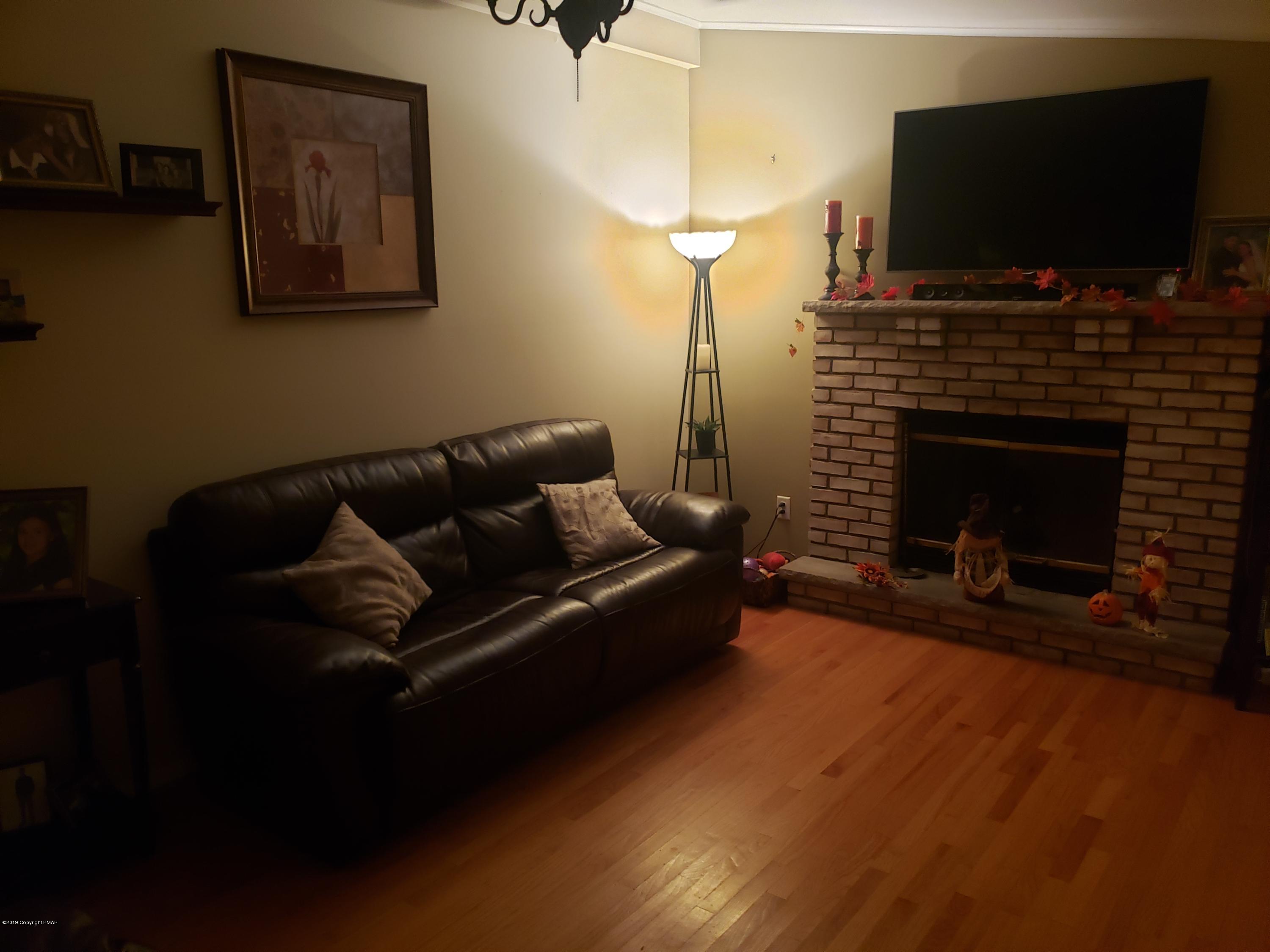 4307 Pine Ridge Drive West Bushkill, PA 18324 - Photo 11 of 28 a living room with furniture a flat screen tv and a fireplace