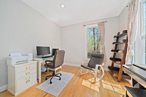 a view of a workspace with furniture and a window