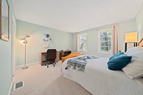 a bedroom with a bed and a table chair